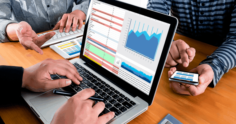 Equipe analisando relatórios e gráficos de desempenho em planilhas e dashboards digitais, utilizando ferramentas de controle de vendas para tomada de decisões estratégicas em um ambiente corporativo.