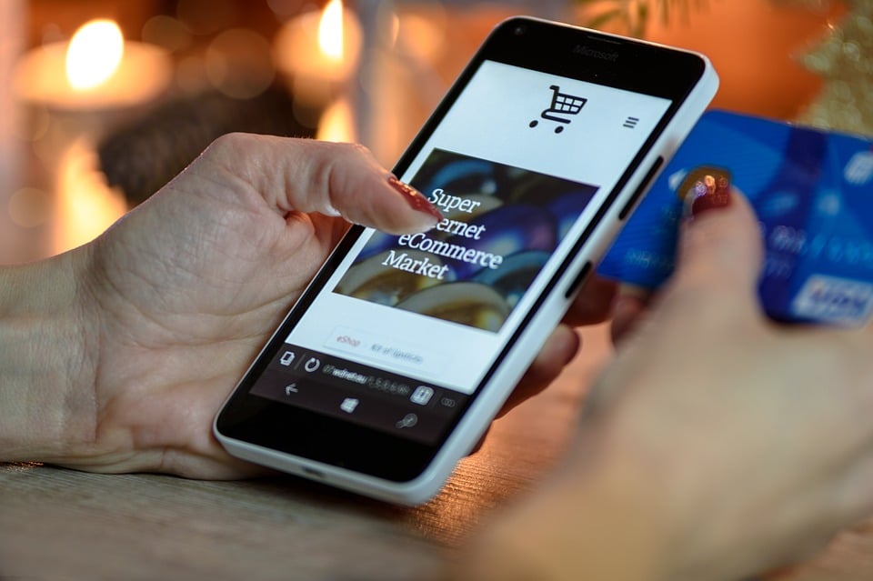 Pessoa olhando um site de compras pelo celular, representando o comportamento do consumidor.