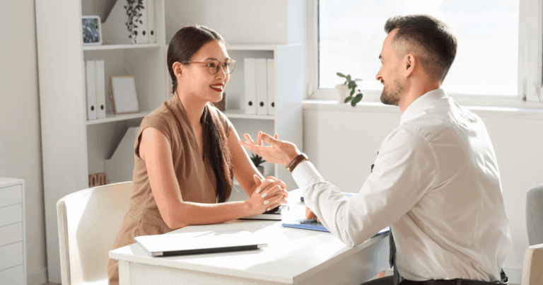 rofissionais em reunião de feedback dentro de um ambiente corporativo, representando práticas modernas de gestão de RH focadas em desenvolvimento e comunicação eficaz.