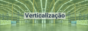 Ao fundo na imagem está um centro de distribuição, organizado em pilhas verticais. No centro da imagem a palavra "verticalização" está em destaque.