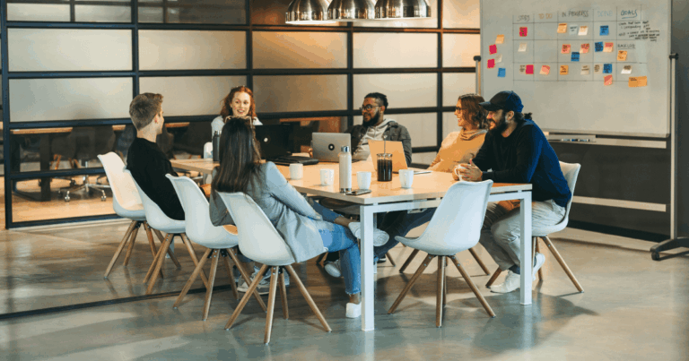 Equipe corporativa discutindo resultados e estratégia que influênciam a PLR( participação nos lucros ou resultados da empresa)