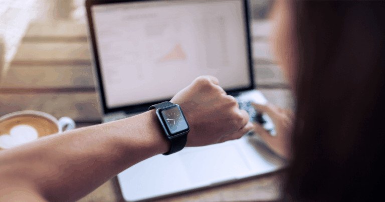 Profissional observando o relógio de pulso, simbolizando a importância da gestão do tempo eficiente no ambiente de trabalho