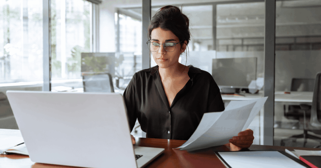 Profissional analisando contrato de terceirização de serviços no ERP com um documento em mãos