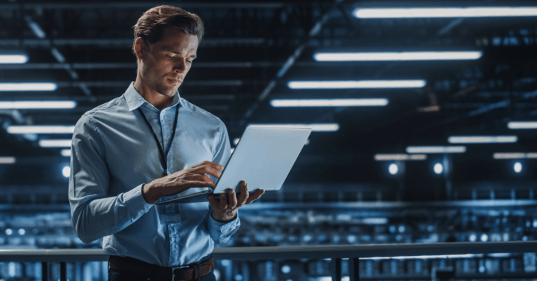 Profissional utilizando notebook em ambiente tecnológico com servidores ao fundo, simbolizando o uso e a gestão de dados em soluções de cloud computing.