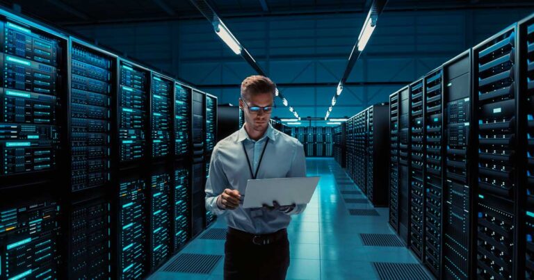 Profissional de tecnologia monitorando servidores em datacenter, ilustrando a gestão de virtual machine em ambientes de alta performance e infraestrutura em nuvem.