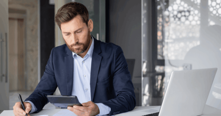 Contador analisando dados fiscais em tablet e notebook no escritório, representando o envio de informações pela DCTFWeb ao governo federal