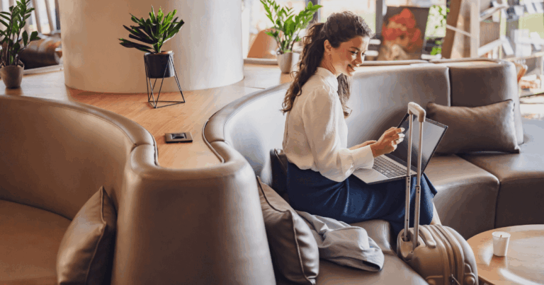 Profissional em viagem corporativa trabalhando remotamente com notebook em lounge de aeroporto, unindo produtividade e mobilidade.