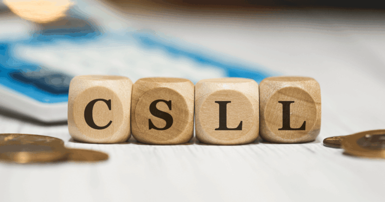 Blocos de madeira formando a sigla CSLL, com moedas e calculadora ao fundo, representando o conceito de Contribuição Social sobre o Lucro Líquido nas obrigações tributárias empresariais.