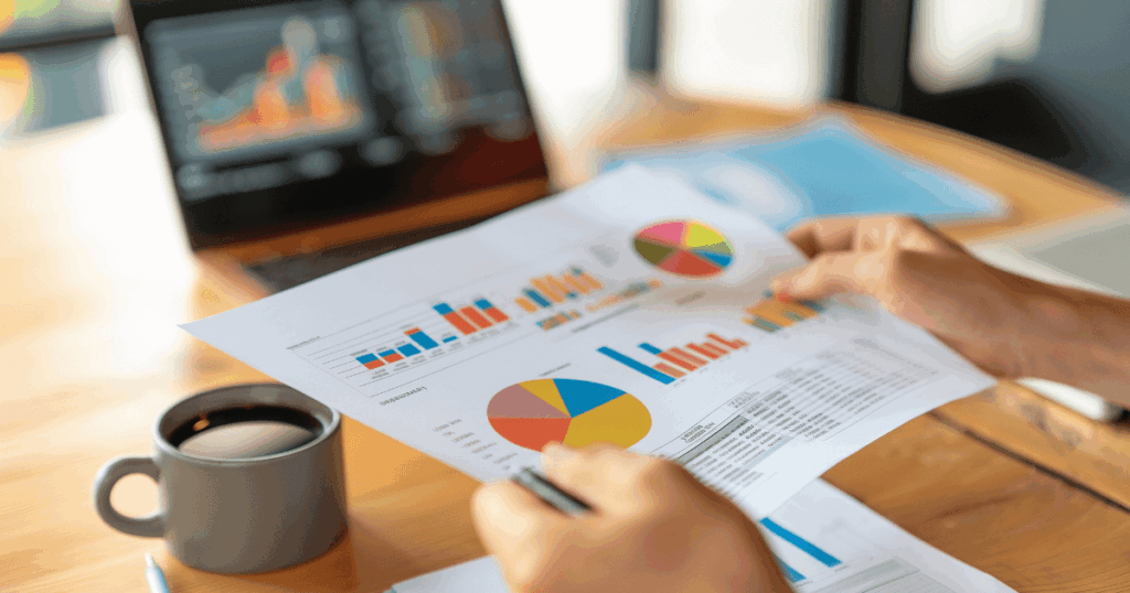 Pessoa analisando gráficos e relatórios com indicadores coloridos, representando o processo de projeção financeira para tomada de decisão estratégica.