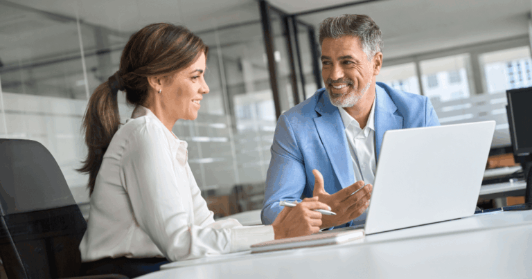 Profissionais do backoffice em reunião corporativa, analisando informações estratégicas no computador em ambiente de escritório moderno.