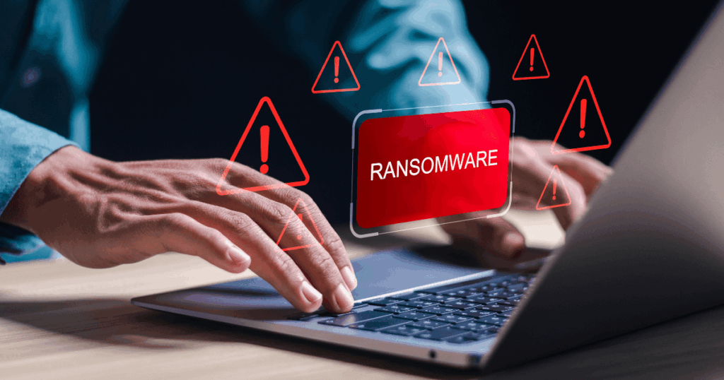 Alerta de ransomware na tela de um notebook, representando ataque cibernético e riscos à segurança de dados empresariais.