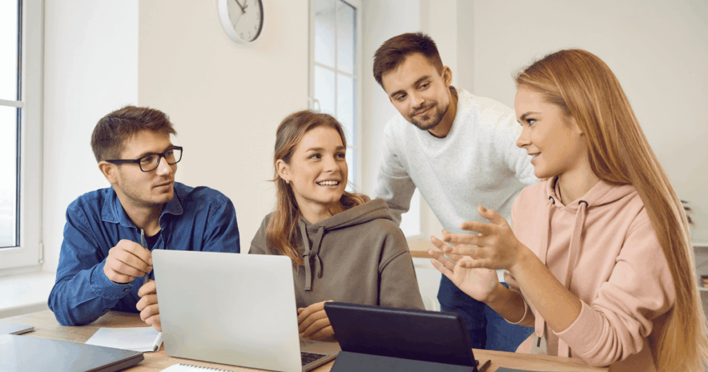 Equipe colaborando em ambiente moderno, representando o conceito de Total Experience com integração entre experiência do cliente, colaborador e usuário.