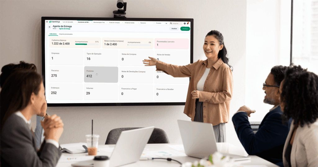 Profissional apresentando em reunião corporativa o painel do Deploy Agent, agente de entregas da Sankhya que automatiza a configuração e deixa o ERP pronto para uso em poucas horas.