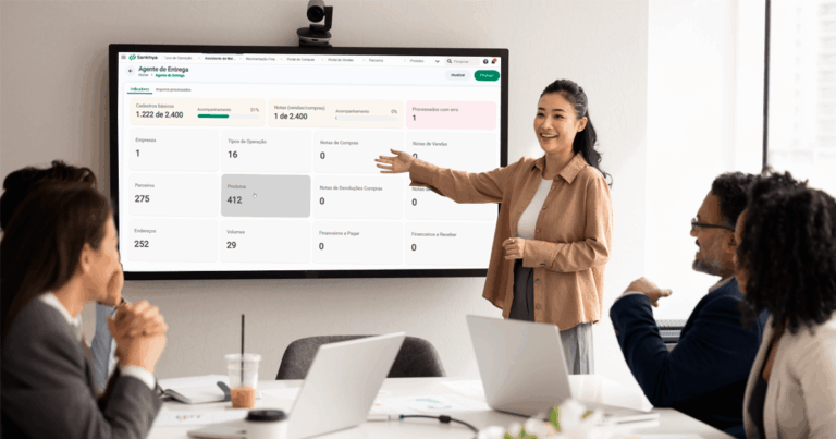 Profissional apresentando em reunião corporativa o painel do Deploy Agent, agente de entregas da Sankhya que automatiza a configuração e deixa o ERP pronto para uso em poucas horas.