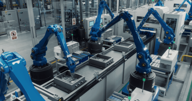 A imagem mostra uma linha de produção automatizada com robôs industriais azuis movimentando peças ao longo de uma esteira. O conceito de takt time é destacado, pois define o tempo necessário para produzir uma unidade de produto, ajudando a coordenar a velocidade de produção com a demanda, garantindo eficiência e evitando desperdícios.