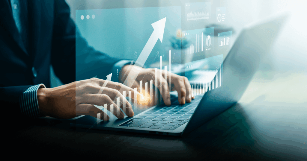 Profissional digitando em notebook com gráficos de crescimento e indicadores financeiros projetados na tela, representando a análise de investimentos, desempenho e cálculo de payback para tomada de decisão estratégica.