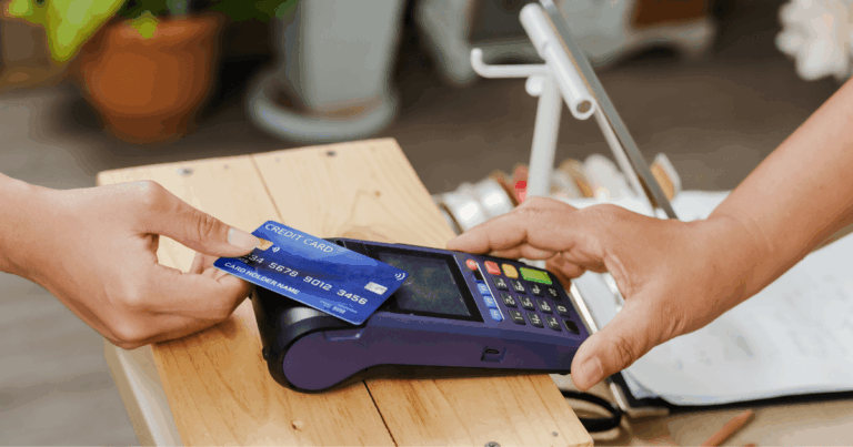 Pessoa realizando um pagamento com cartão de crédito em uma maquininha, ilustrando um arranjo de pagamento em ambiente comercial.