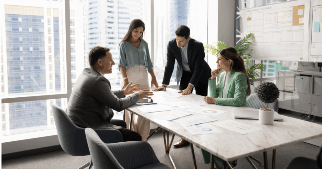 Equipe reunida em escritório analisando estratégias de gestão de vendas e indicadores comerciais em reunião corporativa.