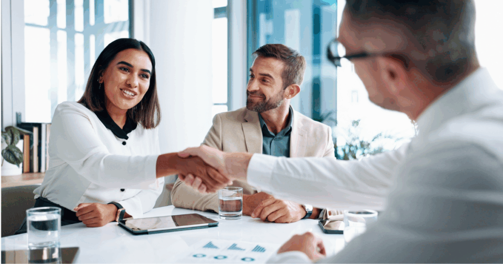 Profissionais fechando uma parceria durante reunião comercial de vendas B2B