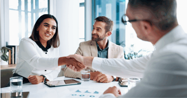 Profissionais fechando uma parceria durante reunião comercial de vendas B2B
