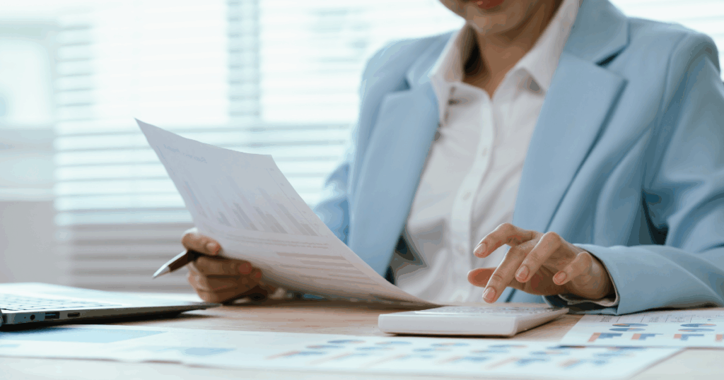 Profissional analisando relatórios financeiros e calculadora para aplicação do custeio ABC na gestão de custos.